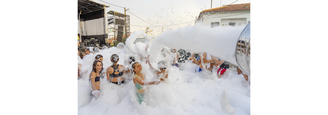 Tłum ludzi bawiący się w jaskrawozielonej, świecącej pianie UV podczas nocnej imprezy klubowej.